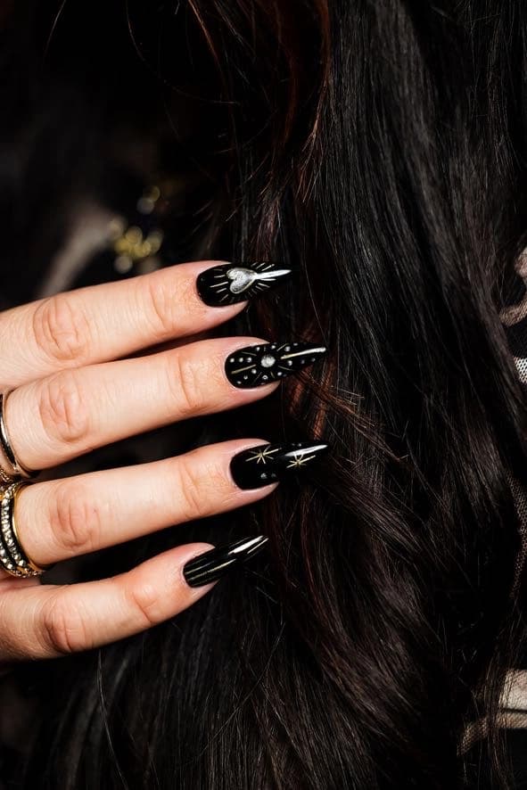 Hand-painted black press-on nails worn by a client.